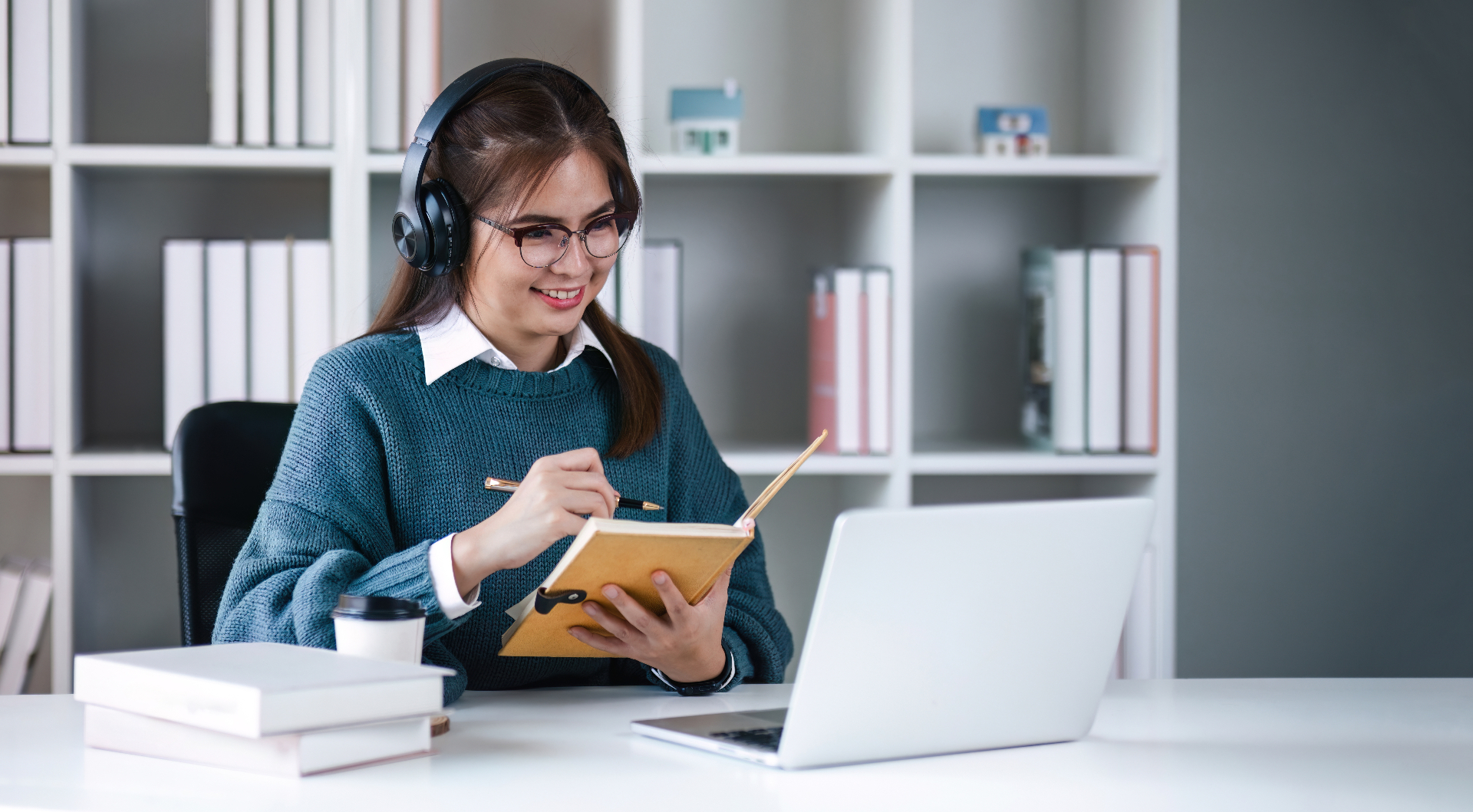 Student studying with headphones and a notebook